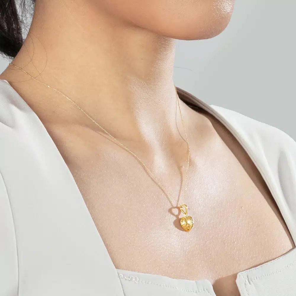 wanita memakai rantai emas 916 berbentuk hati dengan permukaan potongan faceted seperti berlian