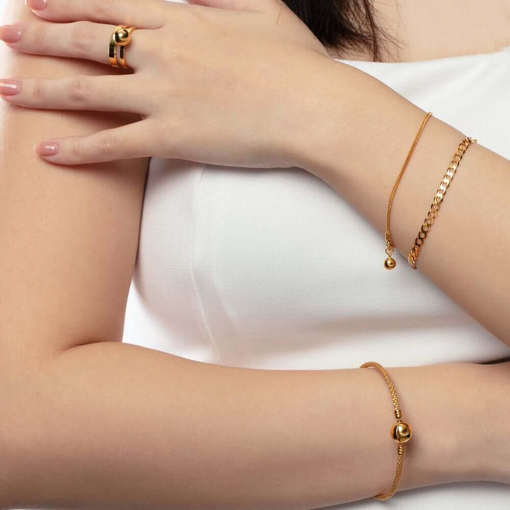 wanita memakai gelang emas 916 terkini dengan reka bentuk badan ular dan sebuah loceng