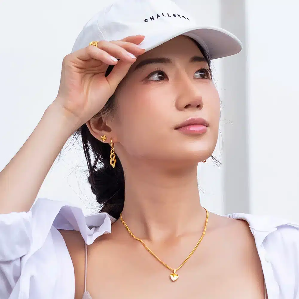 sporty women wearing SK 916 Gold Link Chain Drop Earrings crafted in 916 yellow gold, featuring bold, graduating chain links