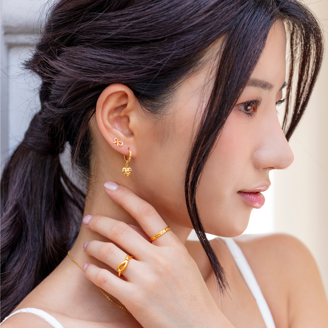women wearing SK 916 Classic Ribbon Gold Stud Earrings in yellow gold, featuring a delicate ribbon-shaped design with butterfly backings