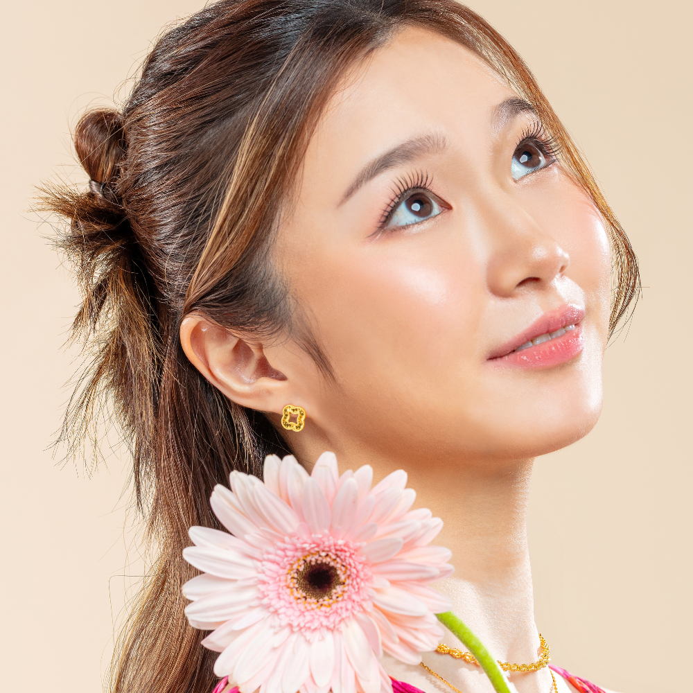 women wearing Luxe Clover 999 Pure Gold Stud Earrings in yellow gold, featuring a faceted four-leaf clover design 