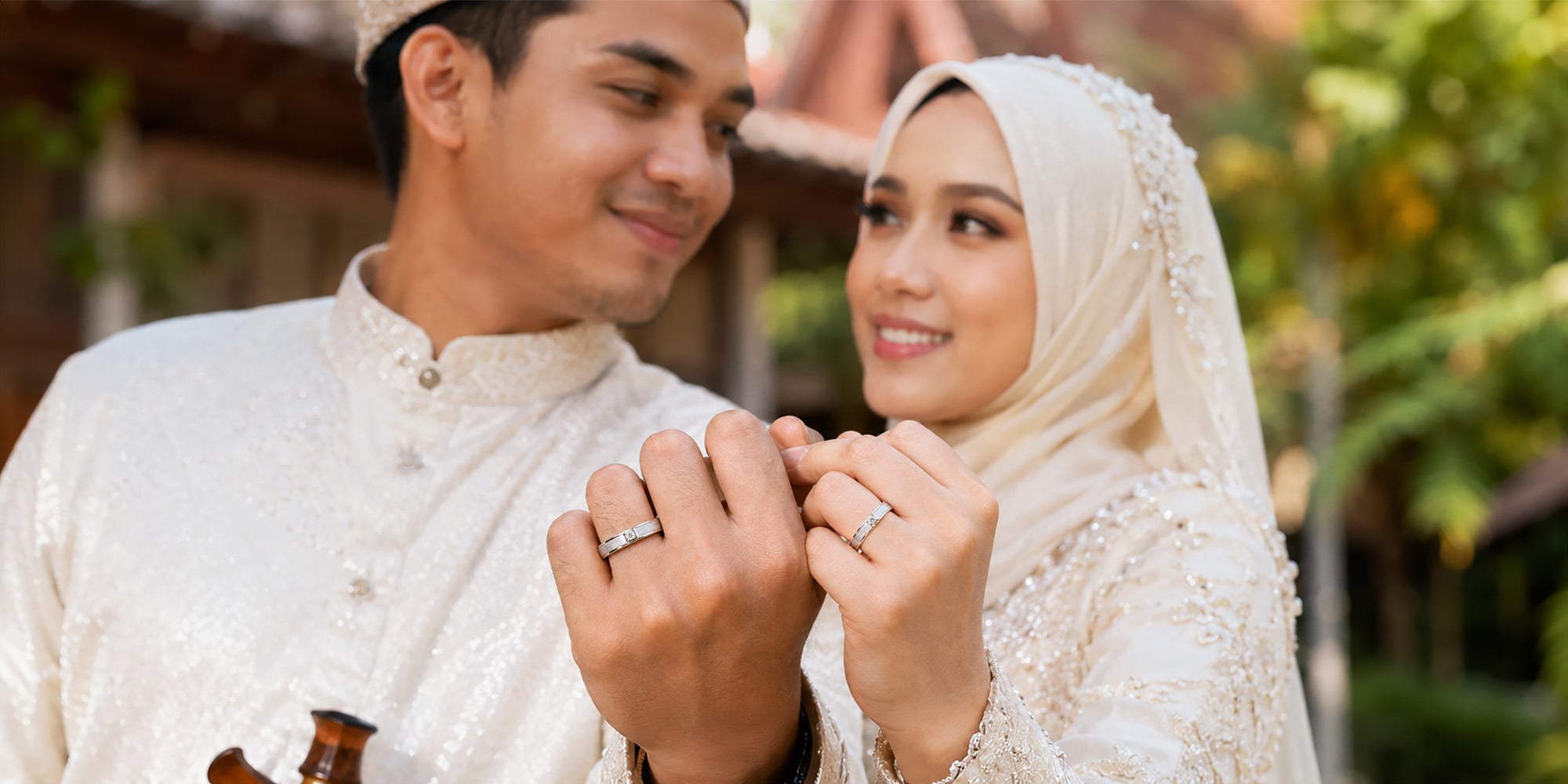 Pasangan Melayu memakai cincin kahwin emas SK Jewellery