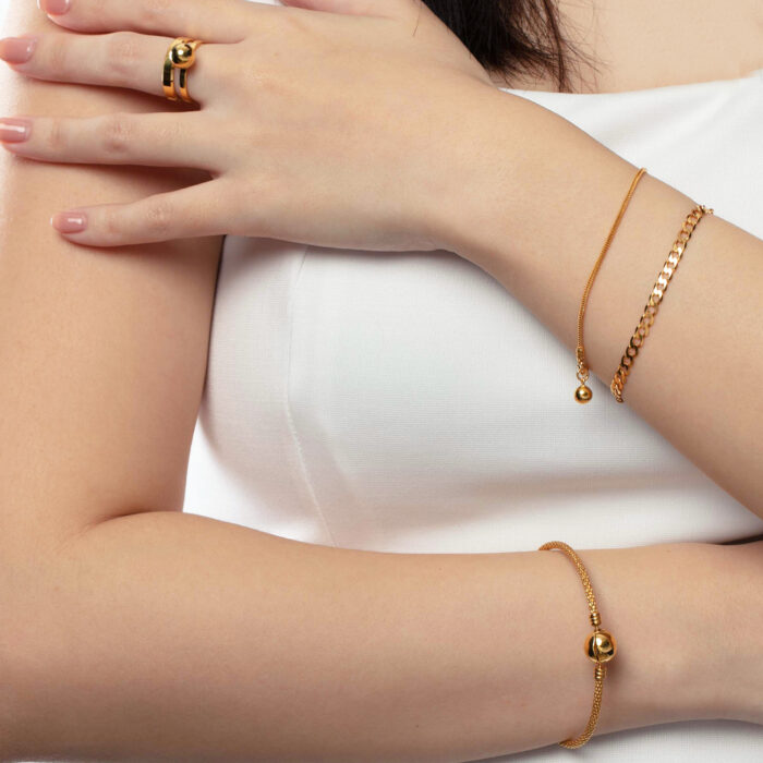 SK BANGLE 916 WITH GOLDEN BALL AND GOLDEN STURDY CHAIN WORN BY A WOMAN PAIRED WITH OTHER ACCESSORIES